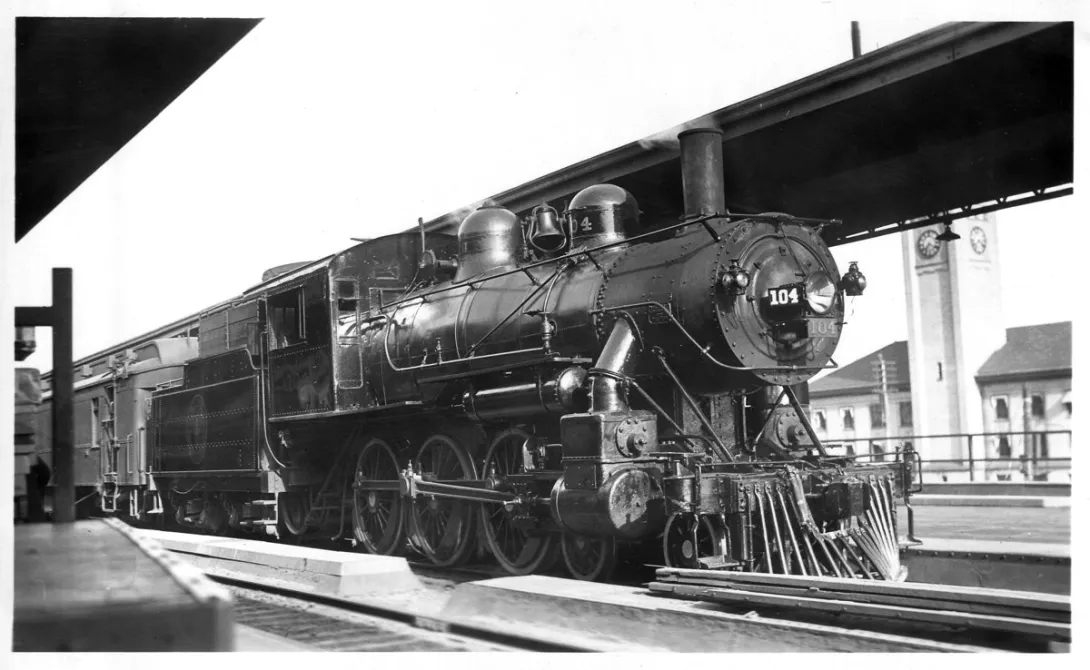 Black-and-white photograph of Spokane International Railroad steam locomotive No. 104 at a station in Spokane, Washington.